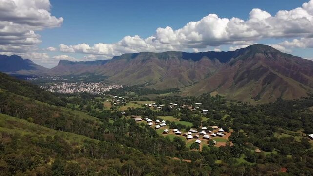 Scenic green valley landscape with traditional hut houses and beautiful mountain ranges in southern African kingdom