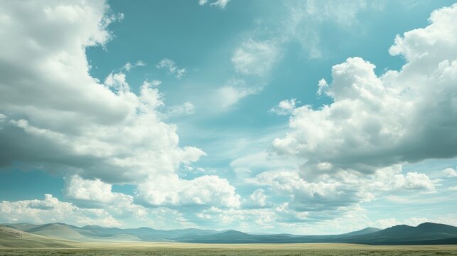 A serene landscape featuring expansive skies filled with fluffy clouds hovering over rolling hills and distant mountains.