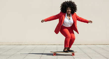 Confident black woman skateboarding in a red suit on urban pavement  