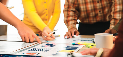 A diverse team collaborates in a bright office, analyzing data and discussing strategies. Colorful...