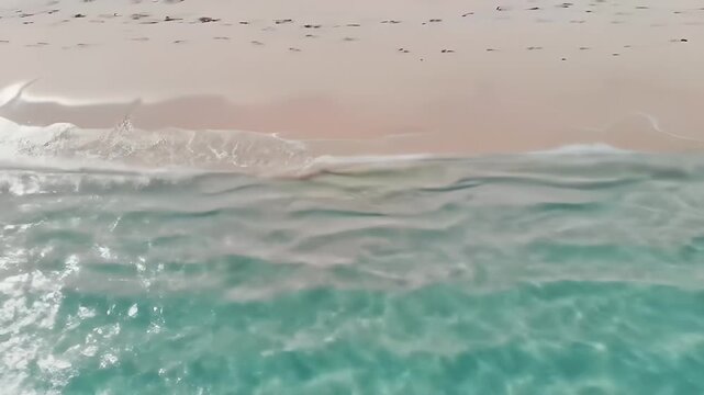 Gentle ocean waves lapping at a pristine white sandy beach.