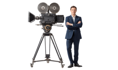 Man stands beside a vintage movie camera
