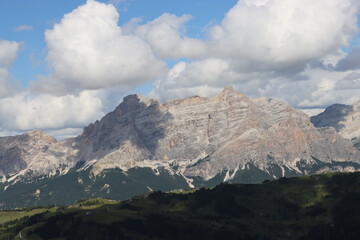 Trentino, Italy - July 29, 2025: Panoramic view of the majestic Piz Boe and the surrounding Dolomite peaks, with lush green valleys and scattered snow, under a clear blue sky. beautiful view to Lake b