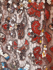 Background with detail of fancy dress headdress with silver and red sequins and glitter. Carnival-printed fancy dress headdresses.
