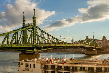 Liberty Bridge with green art nouveau design, decorated with golden spheres and Turul bird statues above the Danube River. Budapest, Hungary.