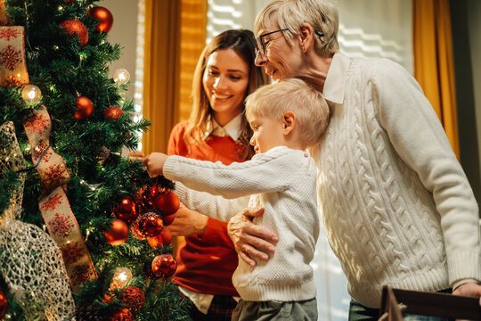 Happy family decorating christmas tree together at home
