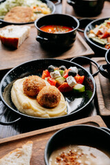 Delicious mashed potatoes with croquettes and fresh vegetable salad on rustic wooden table