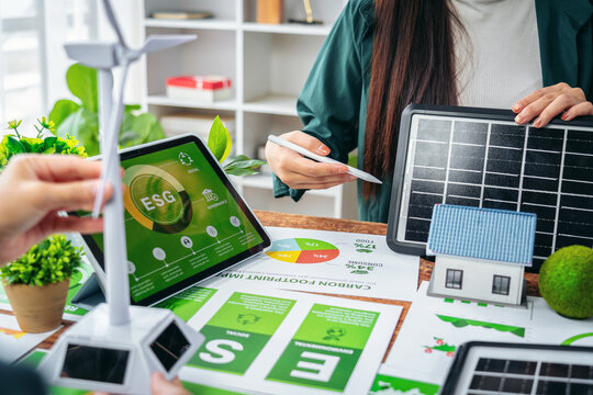 Business professionals analyze environmental social governance report carbon footprint impact renewable energy solutions for sustainable development planning