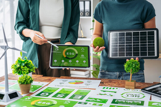 Corporate leaders collaborate on environmental social governance initiatives promoting sustainable business practices green energy solutions at modern office