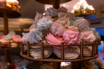 Colorful meringue cookies on a dessert stand.