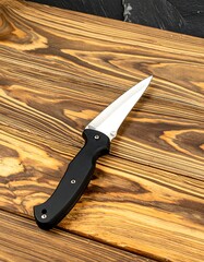 High-quality tactical knife on wood cutting board