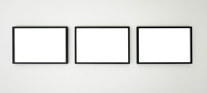 Three horizontal black picture frames hanging on a white wall, clean mockup for artwork, photography