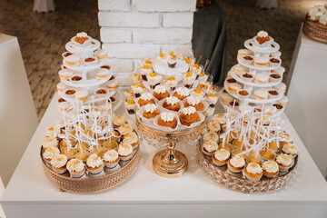 Luxurious wedding dessert table with cupcakes, macarons, and creamy mini treats