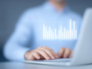 Focused hands typing on laptop with digital bar chart overlay, representing data analysis and business growth concept