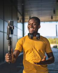 Obraz na płótnie Canvas Excited influencer creating content with smart phone gimbal