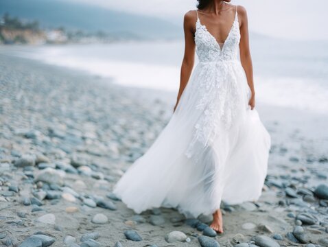 Bride walking barefoot on rocky beach