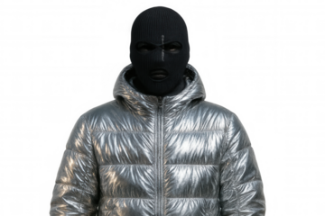 Mysterious individual wearing silver jacket and balaclava, standing against transparent backdrop with enigmatic presence