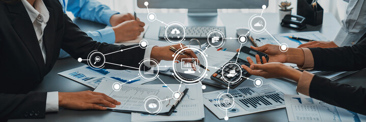 A diverse group of professionals collaboratively analyzing data and presenting strategies with digital tools in a modern office setting focused on teamwork and productivity. Amity