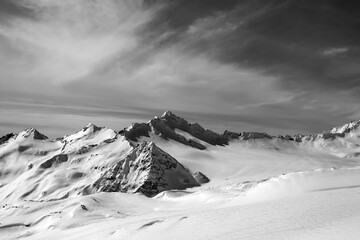 Black and white view on off-piste slope at sun evening