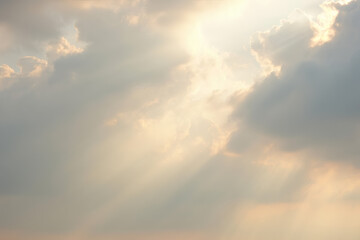 Obraz premium Heavenly Rays: Sunbeams pierce through the clouds, illuminating the sky with a sense of wonder and peace. The sunlight filters through the fluffy, wispy clouds.