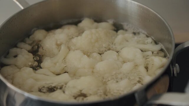 Boiling cauliflower florets in a pot during meal preparation at home in the afternoon