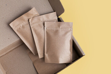 Kraft brown paper empty bags isolated mock up on yellow background. Eco friendly pack with zipper,...