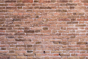 Close-up of ancient stone wall with irregular blocks and earthy colors, showcasing rustic texture for backgrounds, design, or historical architectural references