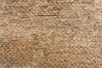 Aged stone and brick wall with uneven surfaces, showcasing rustic character and natural weathering effects