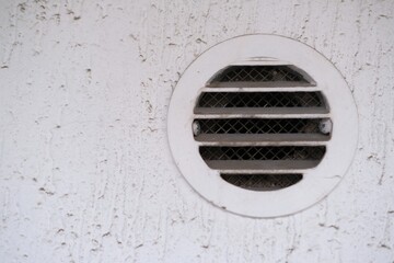 White round dirty and dusty air vent panel on wall of residential building. Ventilation and temperature regulation. Maintenance of household, interior or exterior air grille. Cleaning services