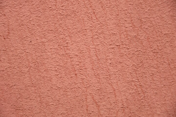 Color of the year 2024 , 13-1023 Peach Fuzz color, plain textured background. Red pink in plaster stucco cement concrete wall pattern texture backdrop. front view