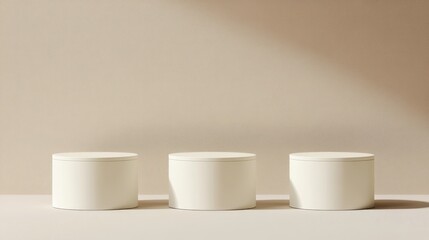 Three white pedestals on beige background with soft lighting