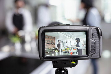 Culinary experts team teaching online cooking class recording on camera, detailed master class on food preparation and fine dining techniques. Aiding students refine their cooking skills.