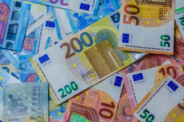 Euro banknotes of different denominations on table close up