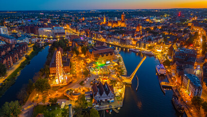 Fototapeta premium Sunset panorama of Gdansk behind a ferris wheel, Poland