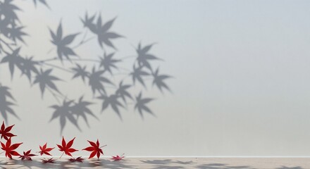 Vibrant red maple leaves are scattered on a light wooden floor, with intricate shadows of tree branches and foliage cast across a minimalist neutral wall, creating a serene autumnal scene.