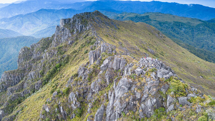 Frontal horizontal shot of a landscape with a rock formation surrounded by paramo at the summit of Cerro Urán on a cold morning in Chirripo National Park, Costa Rica. © Saintdags