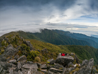 Young male hiker resting lying down near the summit of Cerro Urán on a cold morning in Chirripo National Park, Costa Rica. © Saintdags