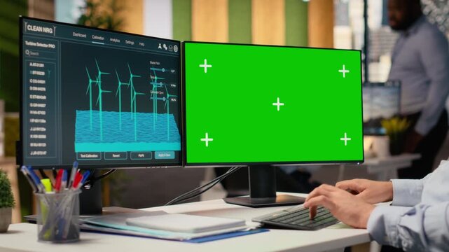 Engineer using software on green screen mockup PC used for planning wind farm layouts. RD department expert using CAD program on chroma key computer to design windmills farm configurations