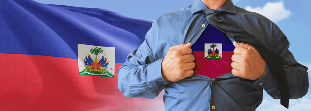 A businessman opening his shirt like super hero with Haiti flag and shows how patriotic he is by revealing his countries flag beneath printed on a t-shirt.