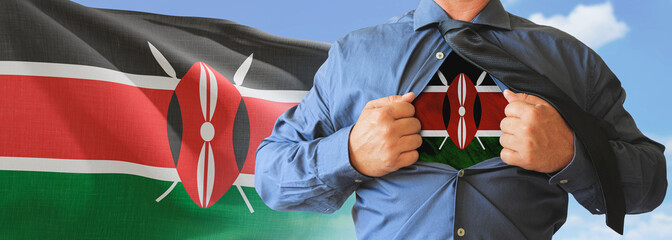 A businessman opening his shirt like super hero with Kenya flag and shows how patriotic he is by revealing his countries flag beneath printed on a t-shirt.