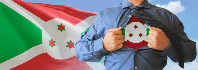A businessman opening his shirt like super hero with Burundi flag and shows how patriotic he is by revealing his countries flag beneath printed on a t-shirt.