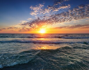Obraz premium beautiful sunrise over tranquil ocean waters with colorful cloudy sky and gentle waves