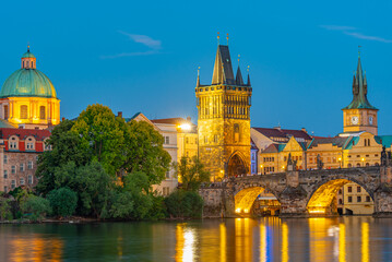 Fototapeta premium Sunset view of Charles bridge and Saint Salvator church in Pragu