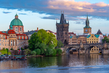 Fototapeta premium Sunset view of Charles bridge and Saint Salvator church in Pragu