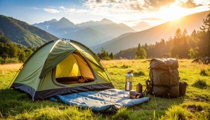 Camping gear setup with tent, backpack, stove, and lantern on grass with mountains background. Realistic travel essentials photo for outdoor adventure lifestyle