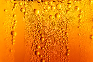 Detailed macro photograph of golden bubbles in a carbonated drink, abstract background with sparkling fizzy texture
