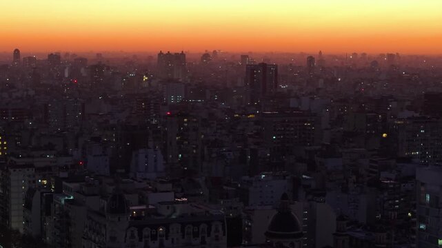 Vista a&eacute;rea de la ciudad de Buenos Aires al atardecer. Cielo naranja, paisaje urbano, hora m&aacute;gica, calma y belleza arquitect&oacute;nica.