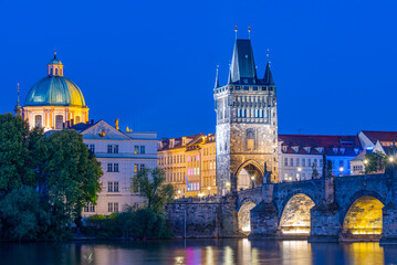 Obraz premium Sunset view of Charles bridge and Saint Salvator church in Pragu