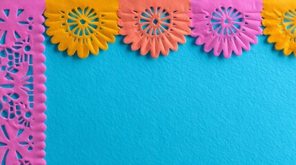 Colorful Papel Picado banner over a blue background. Mexican folk art decoration for Day of the Dead celebration. Traditional cut paper design.
