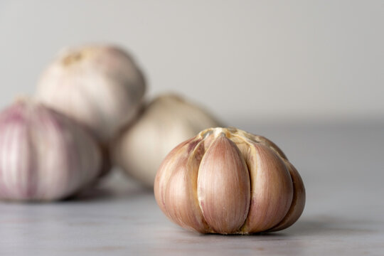 Bulb of purple garlic with the skin removed on a light surface 